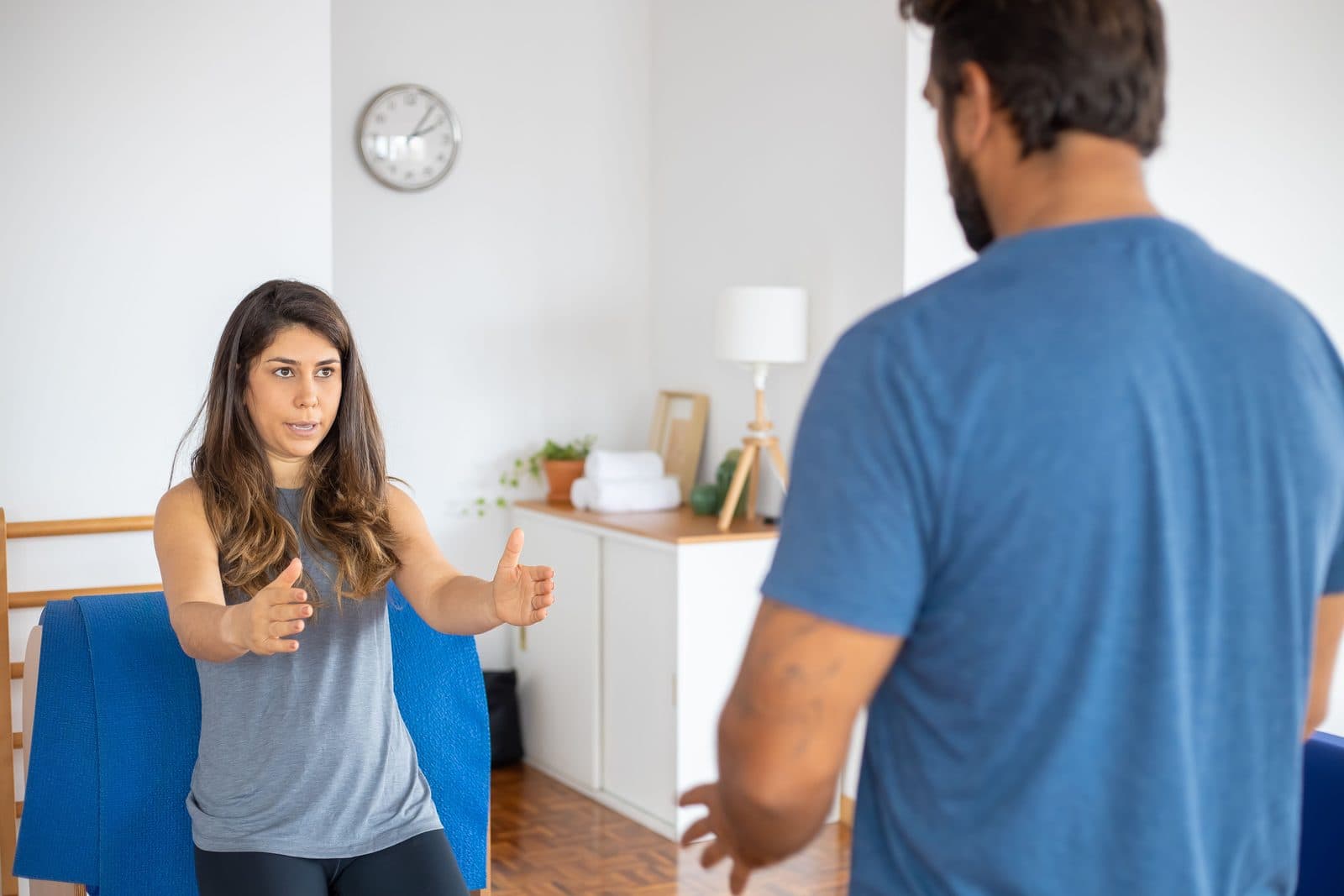 Coach reviewing movement with a client in a home training space