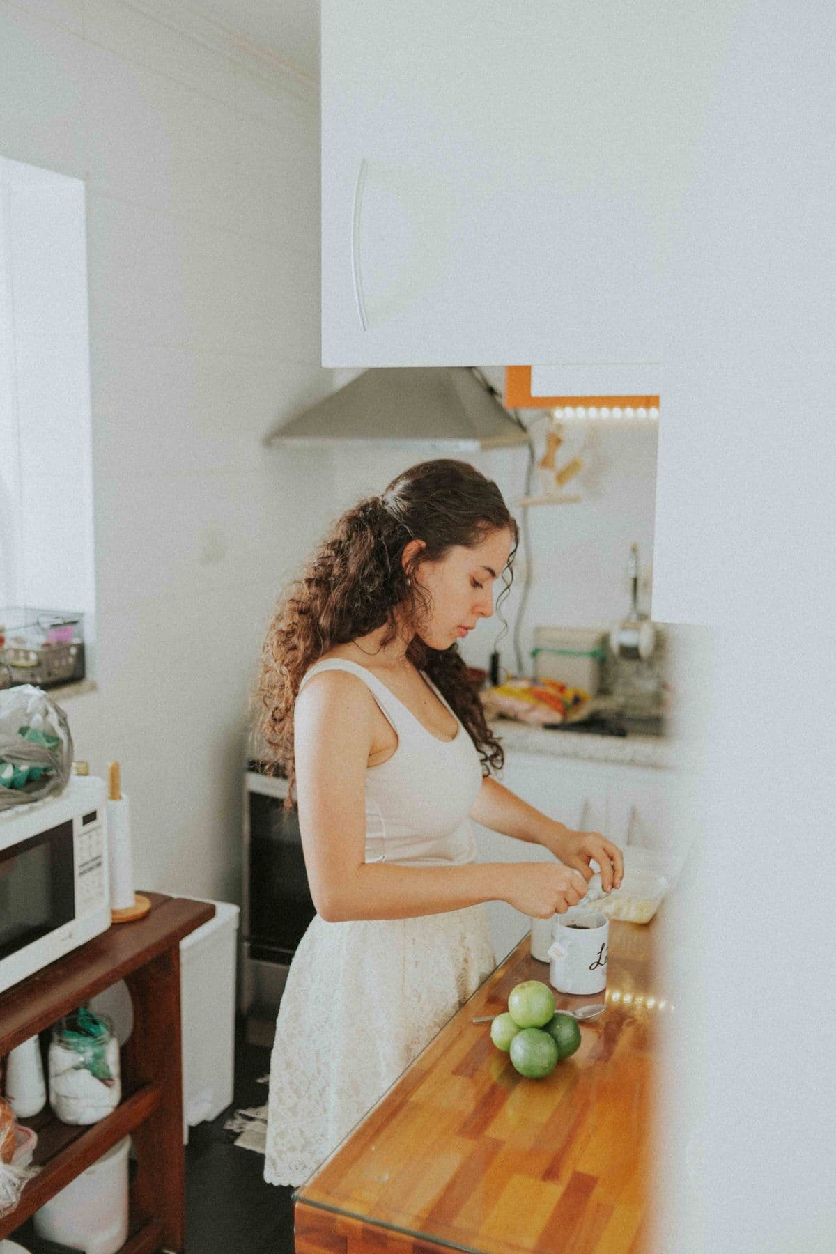 Woman preparing a meal with fresh ingredients in a bright kitchen
