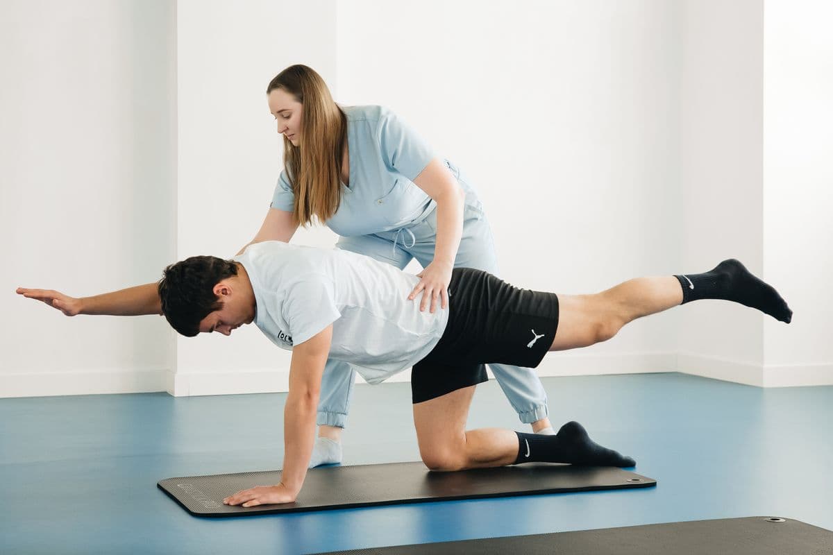Trainer assisting a client with a progressive standing exercise