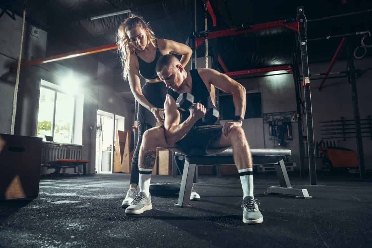 A trainer coaching a client through a strength workout