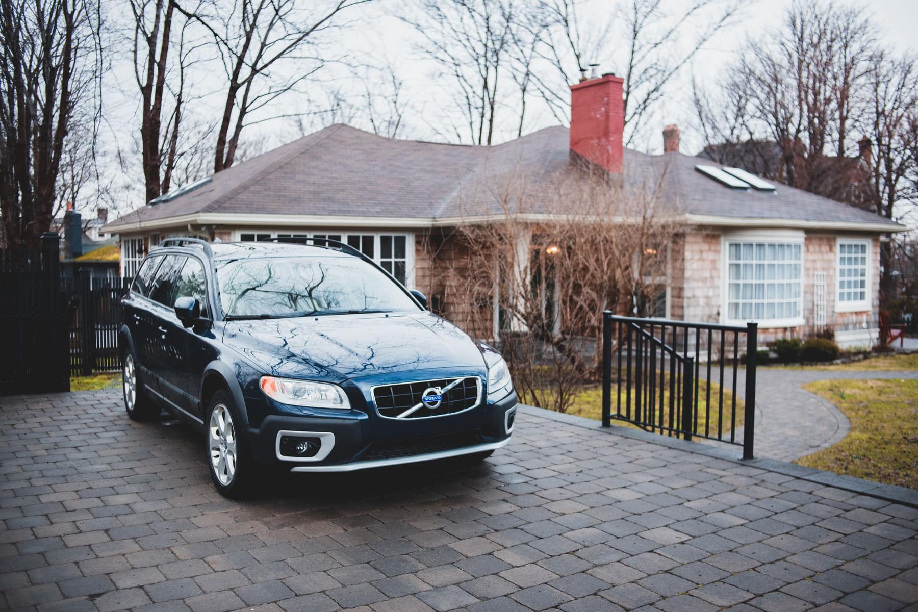 A coach's wagon parked in a client's driveway on an overcast morning