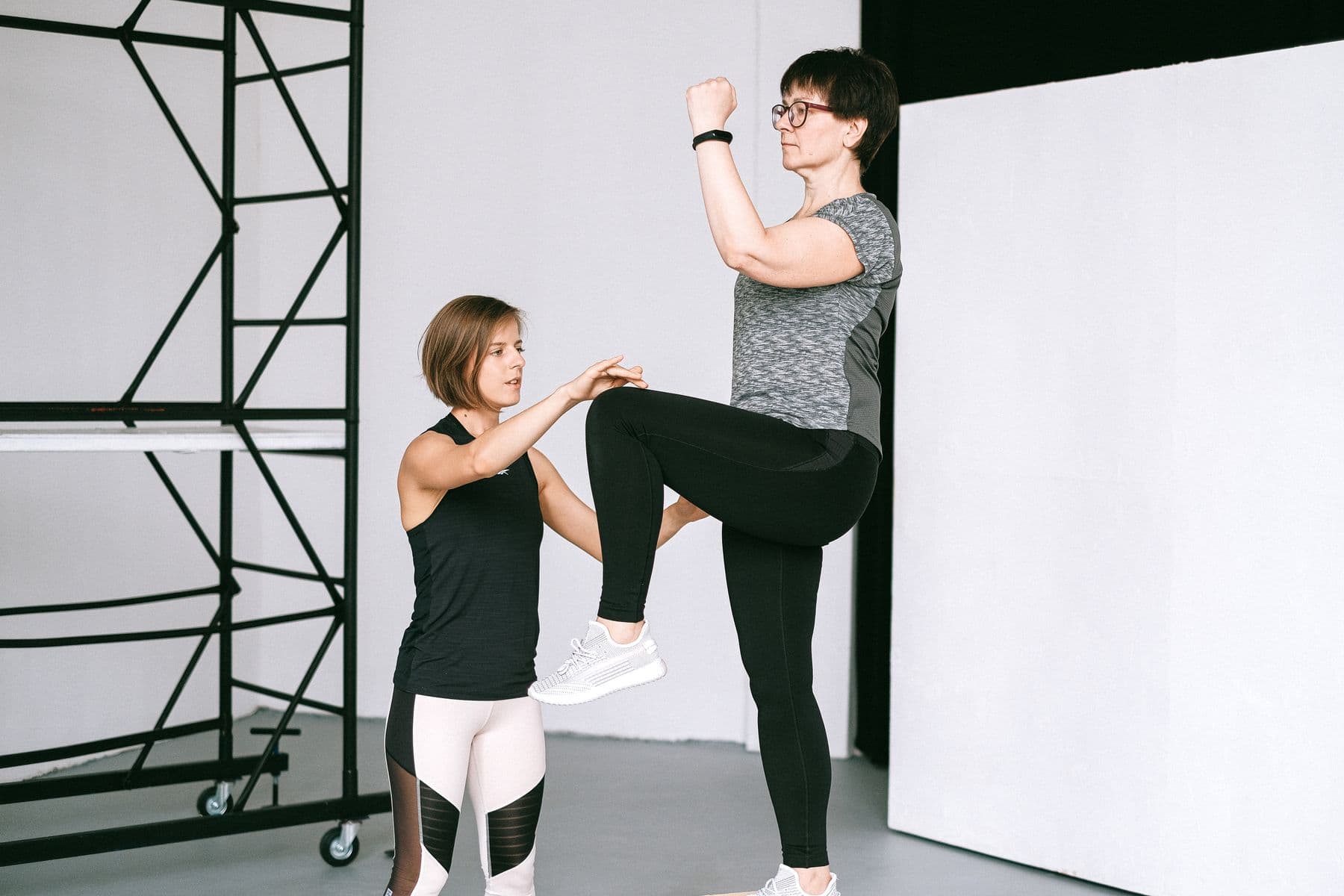Trainer coaching an older adult through a supportive band drill